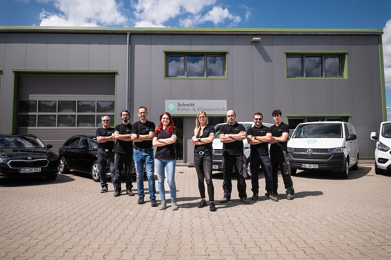 Das Team von Schmitt Kälte- und Klimatechnik vor der Fahrzeugflotte am Firmengebäude