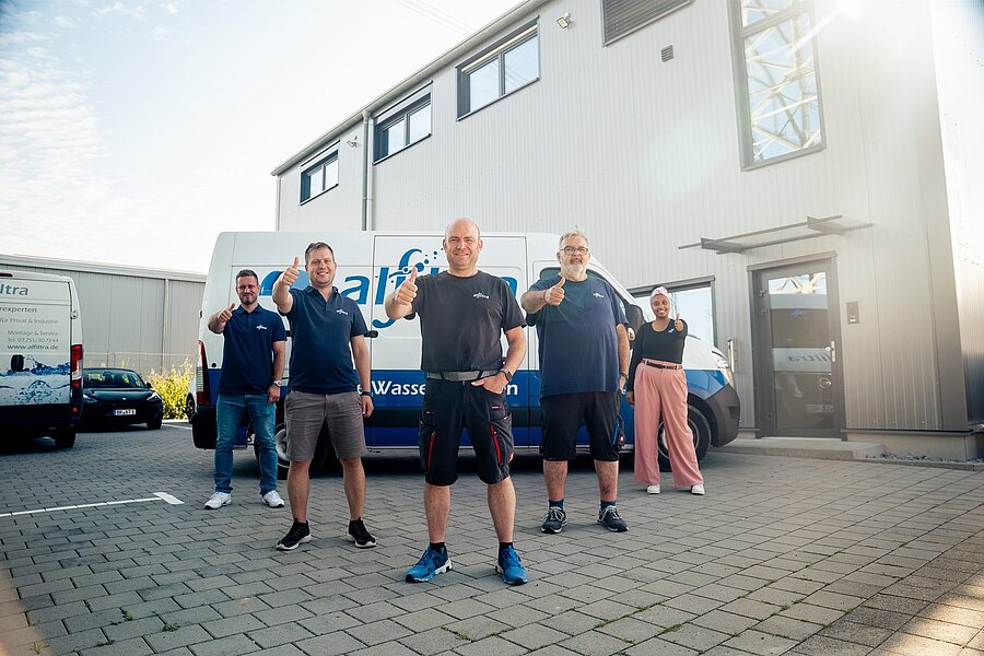 Das Team von Alfiltra vor Firmengebäude und Transporter