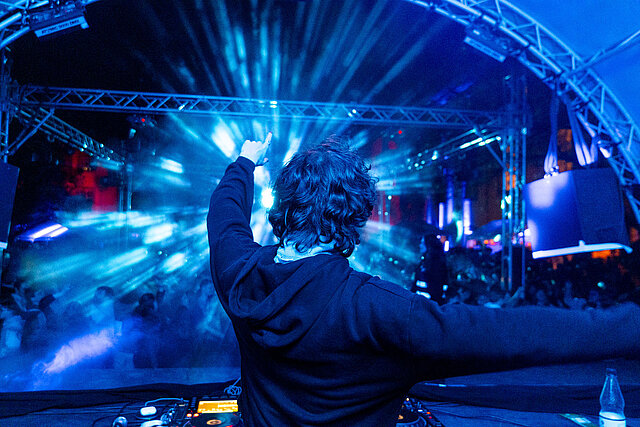 DJ auf der Bühne mit Lichtshow beim Festival — Eventfilm