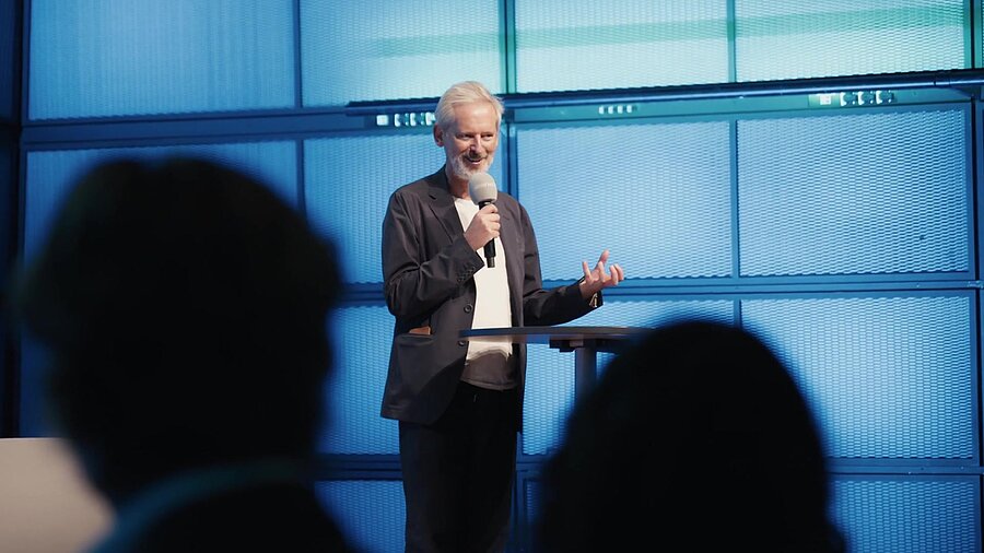Innovationscampus Nachhaltigkeit — Speaker mit Mikrofon beim Event in Karlsruhe