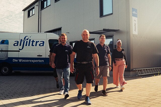 Team von Alfiltra, den Wasserexperten, vor dem Firmenwagen