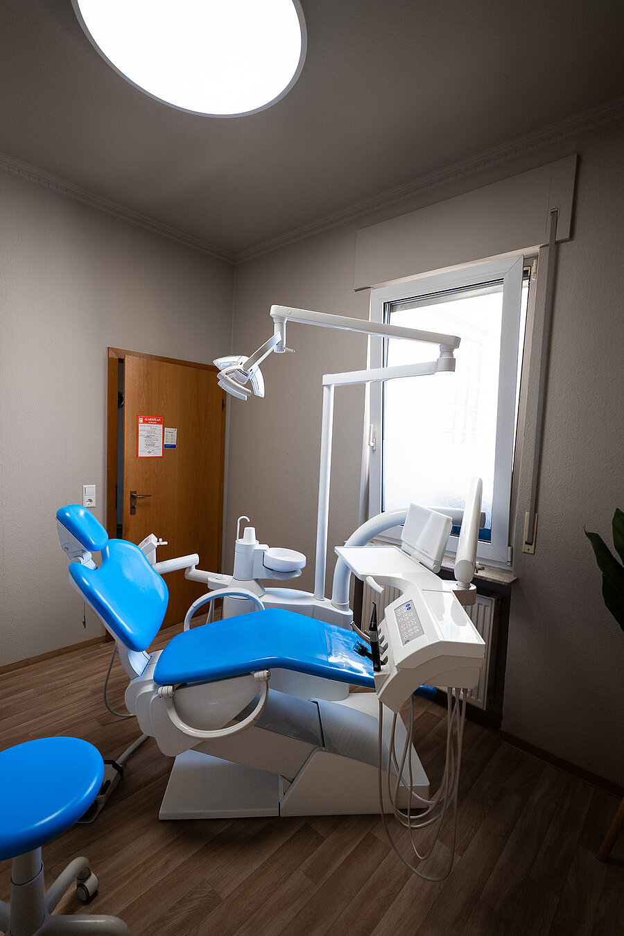 Behandlungszimmer einer Zahnarztpraxis mit Behandlungsstuhl und Tageslicht